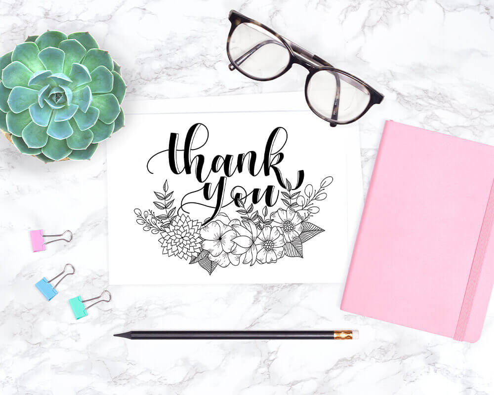 Thank you Card printable displayed with glasses and pink notebook