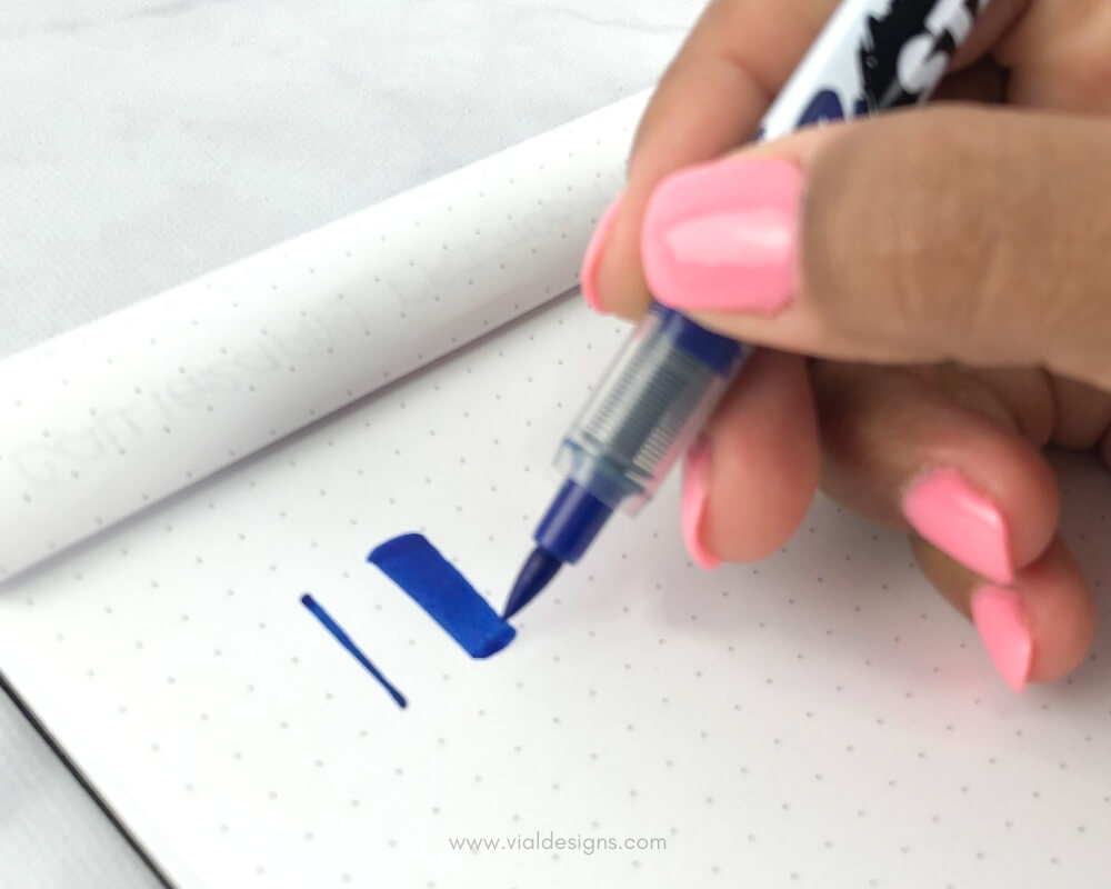 demonstrating thin and thick calligraphy strokes by Vial Designs using a blue Sharpie Stained Fabric Marker